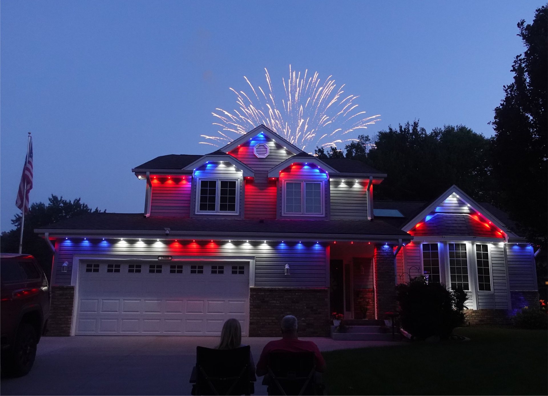 The same Omaha home lit by Fairacres permanent architectural lighting at dusk